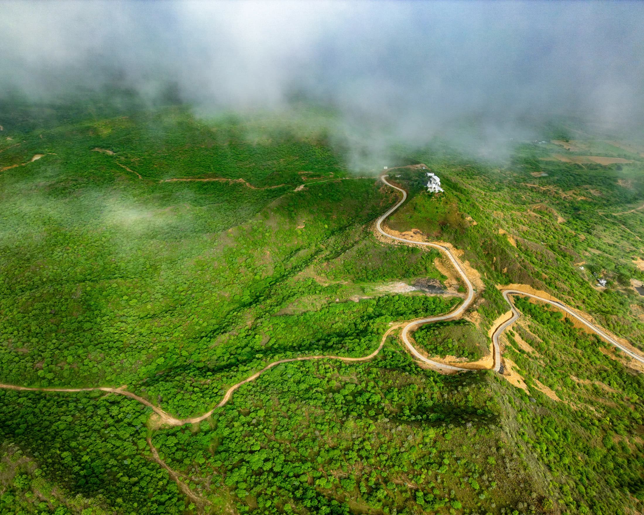 Kalo Dungar Black Hill aerial view with winding road and green hillside